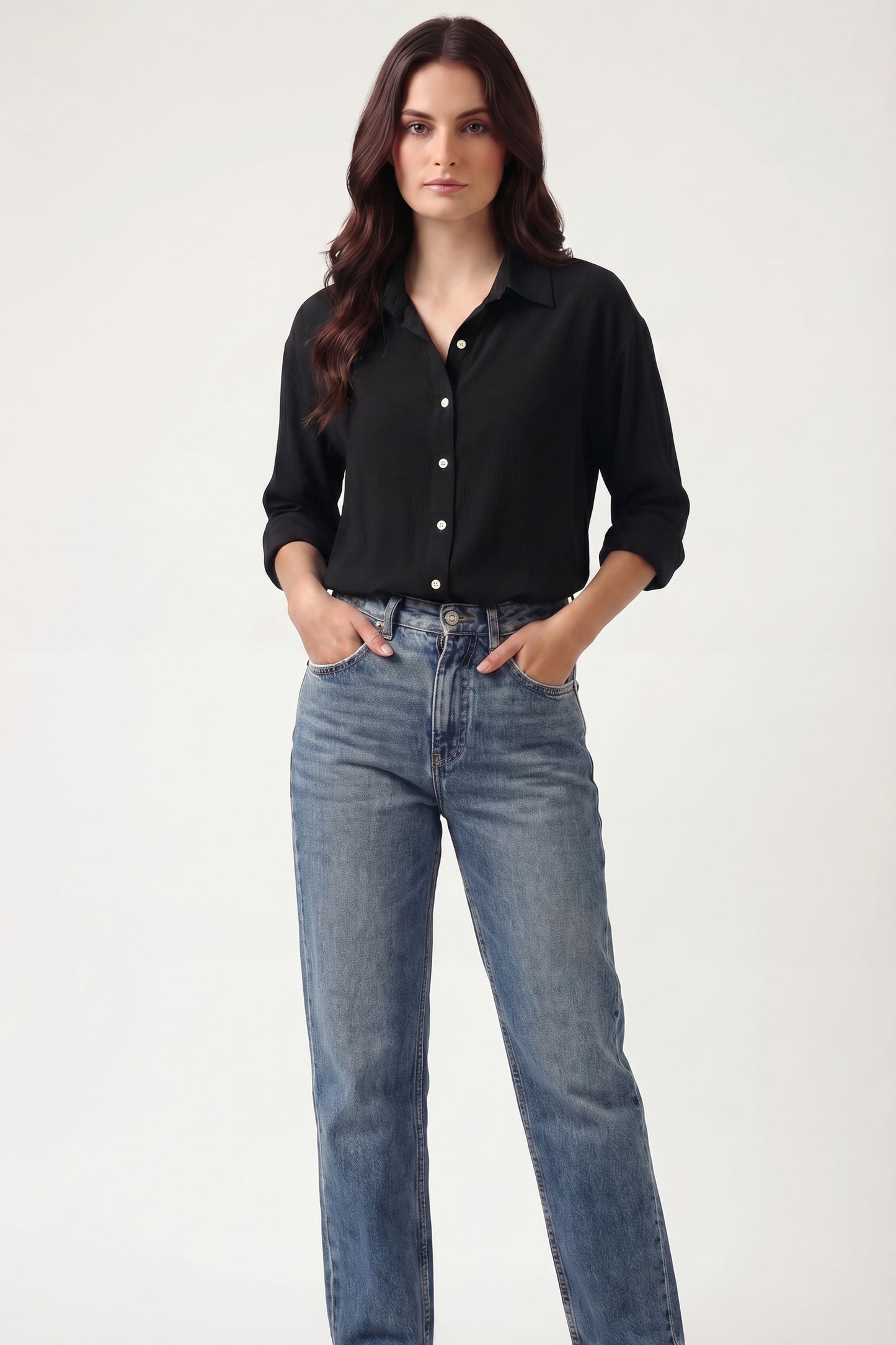 Woman wearing a black shirt and blue jeans on a white background