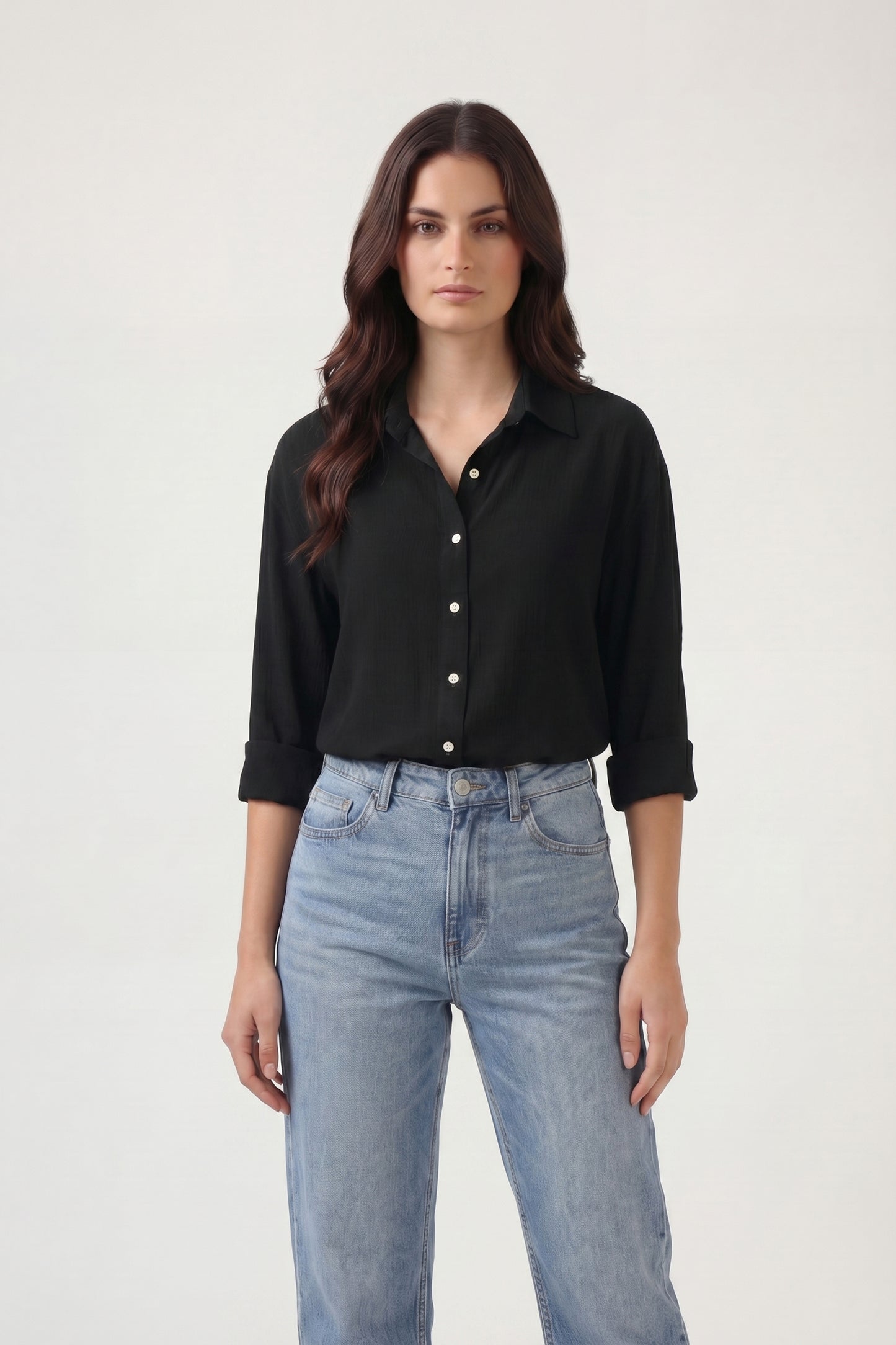 Woman wearing a black shirt and blue jeans on a white background