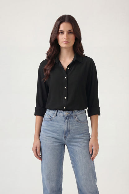 Woman wearing a black shirt and blue jeans on a white background