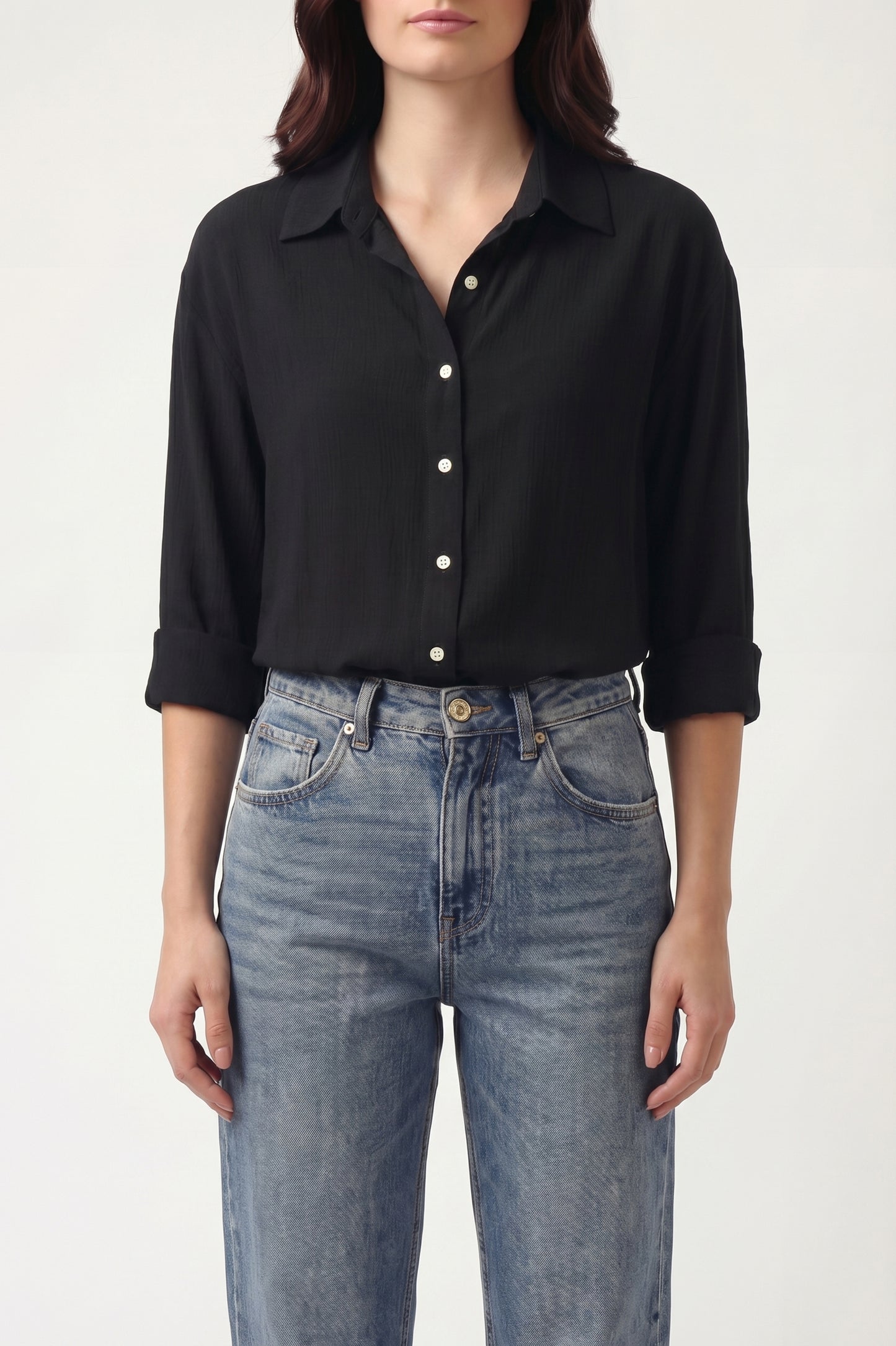 Person wearing a black shirt and blue jeans on a white background