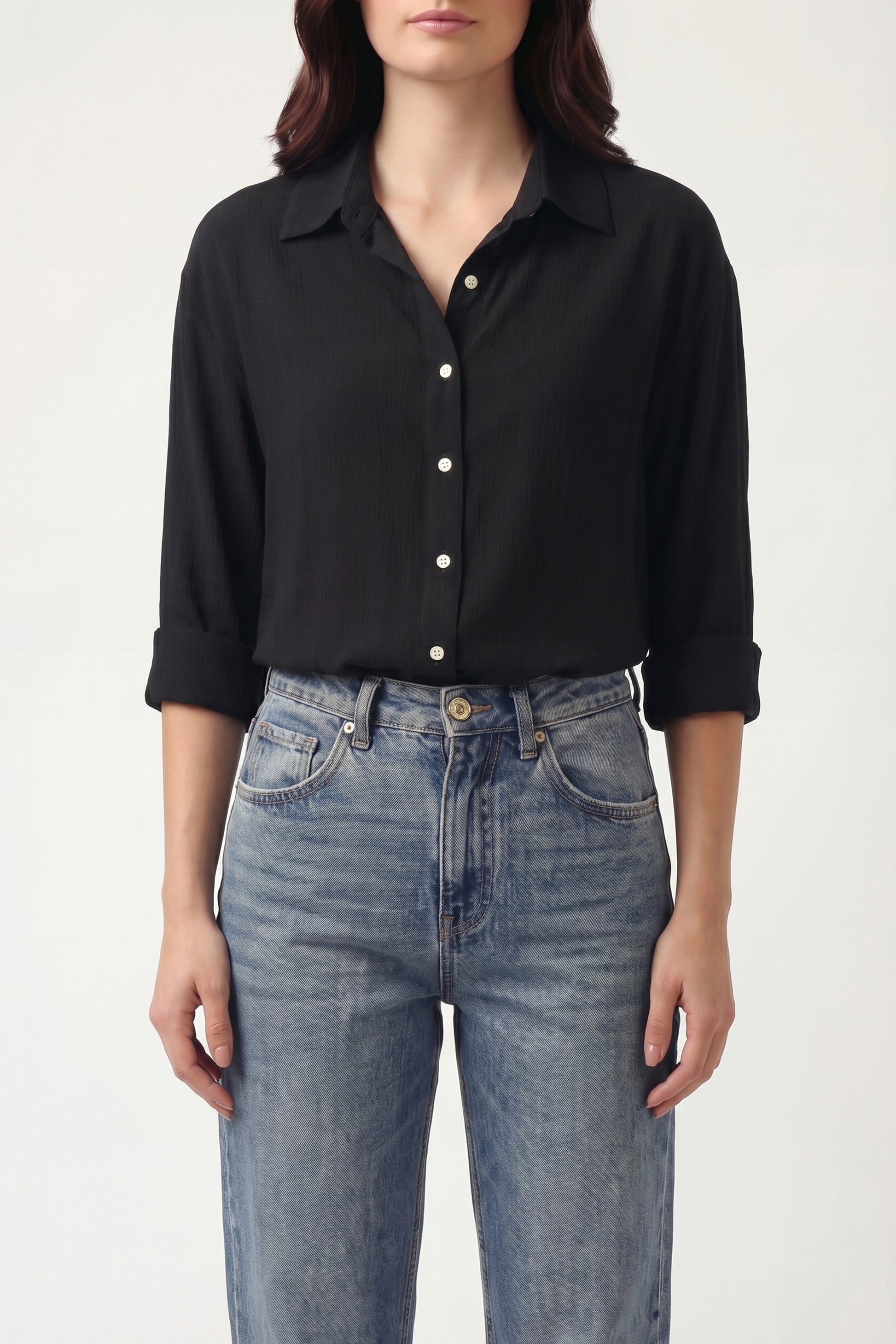 Person wearing a black shirt and blue jeans on a white background