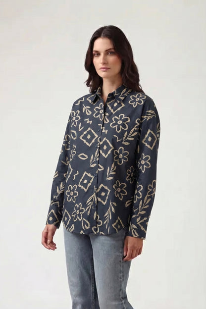 Woman wearing a dark floral patterned shirt on a white background
