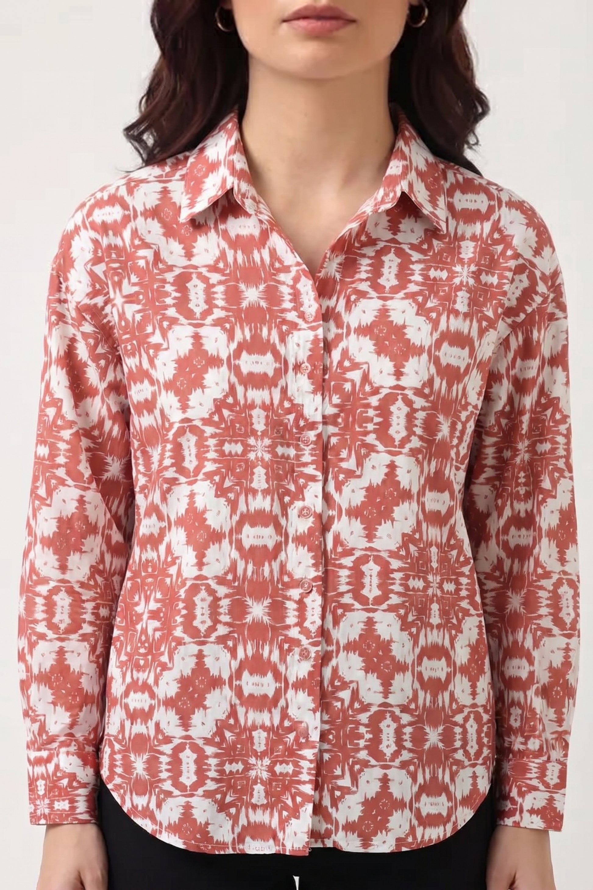 Red and white patterned shirt worn by a person on a white background